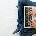Man using laptop computer while sitting on white floor background with copy space, top view, people and technology, lifestyles work at home